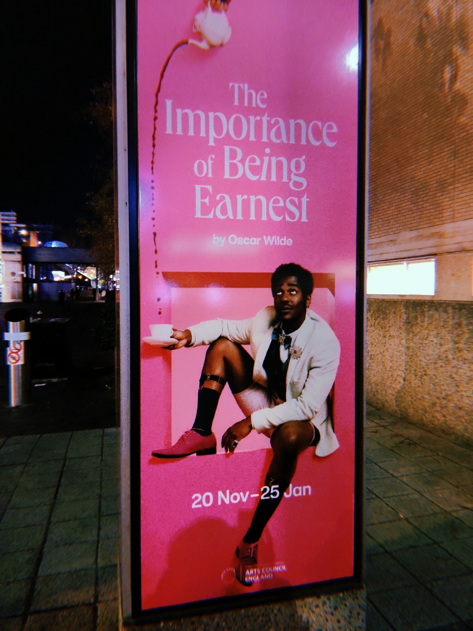 Outdoor poster column for The Importance of Being Ernest with a photo of Ncuti Gatwa in vintage dress.