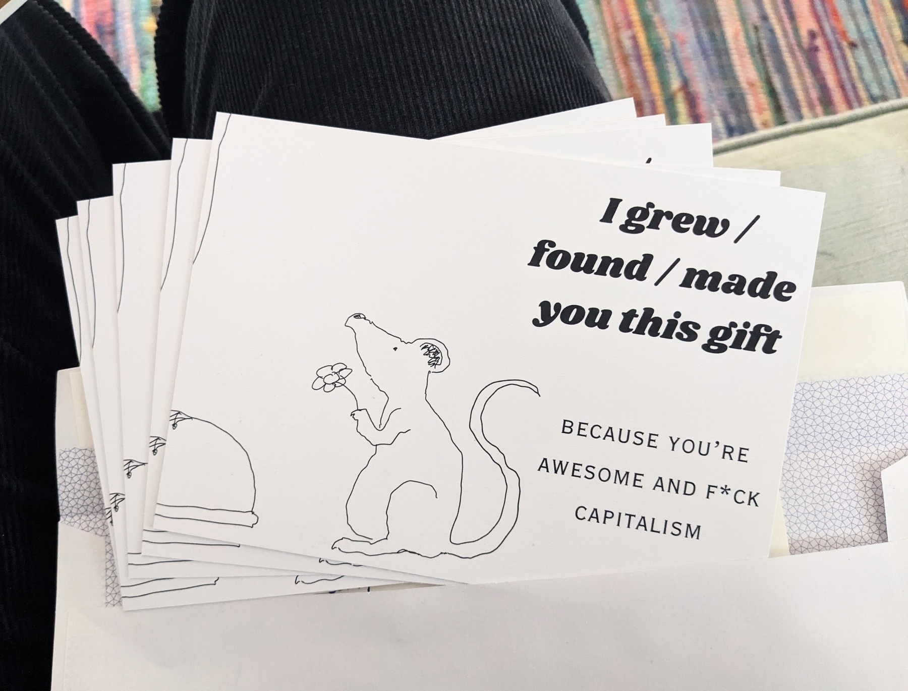 A stack of cards features a drawing of a mouse holding a flower with the message: I grew / found / made you this gift. Because you're awesome and f*ck capitalism